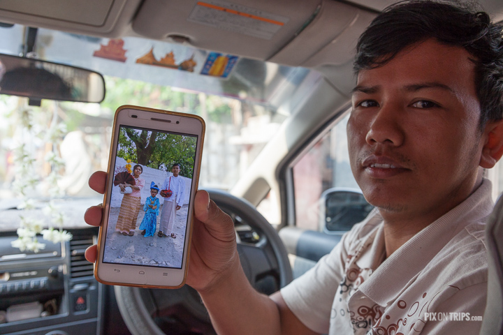 Taxi driver showing photo of family, Mandalay, Myanmar
