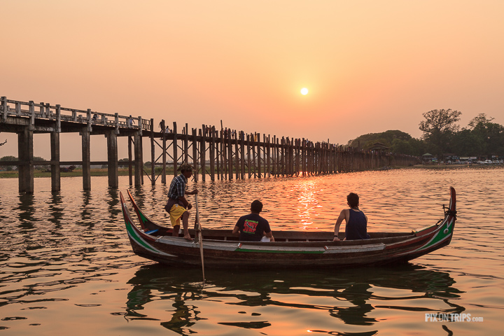Tourists watch sunset from boat beside U Bien Bridge, Mandalay, Myanmar